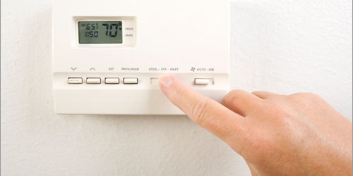 adjusting thermostat in your home