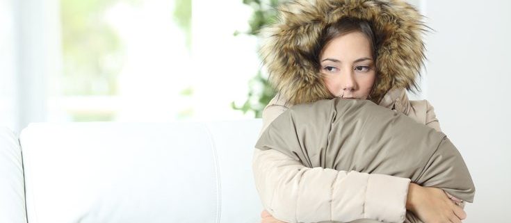 Cold person with cold air blowing out of the furnace