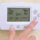 adjusting thermostat in your home